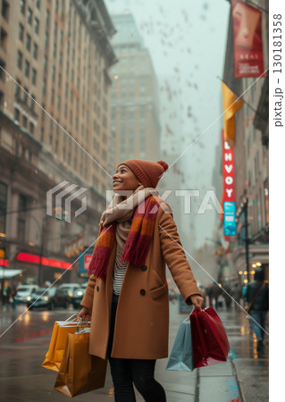 Stylish woman wearing a warm coat enjoys strolling city streets with shopping bags 130181358
