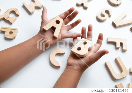 Children wooden alphabet letters held by child hands 130181492