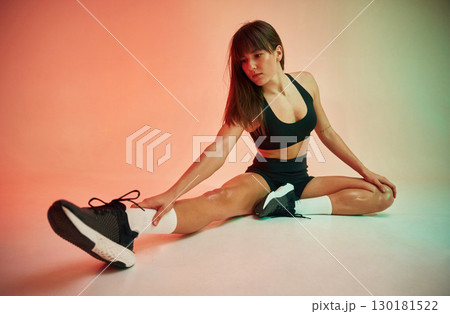 Sitting on the floor. Young woman in fitness clothes is in the studio Sitting on the floor. Young woman in fitness clothes is in the studio 130181522