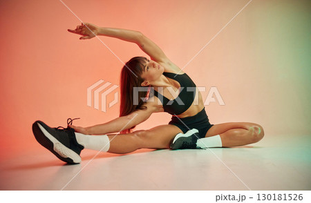 Fitness practice. Young woman in black sportive clothes is in the studio Fitness practice. Young woman in black sportive clothes is in the studio 130181526