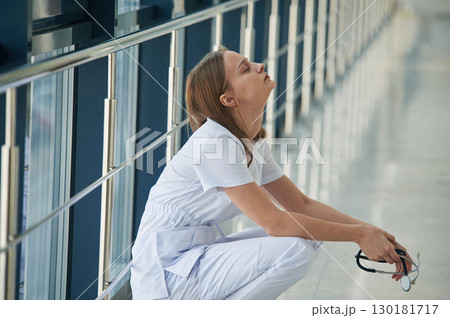 Tired, feeling bad, exhausted. Female doctor in white coat is in the hall 130181717