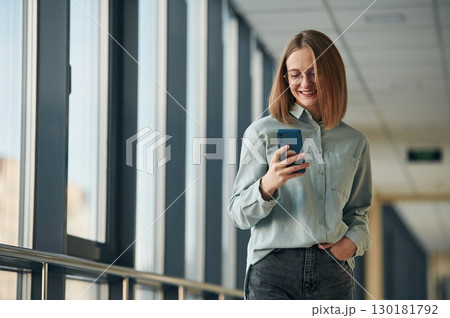 Smartphone in hands. Young woman in airport hall 130181792