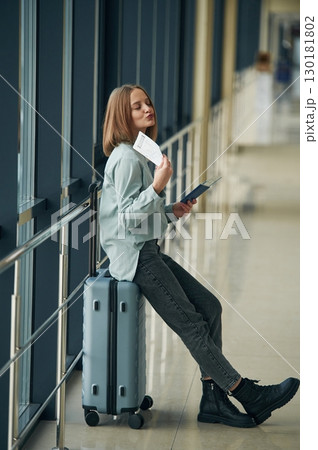 Waiting in the airport hall. Young woman with luggage Waiting in the airport hall. Young woman with luggage 130181802