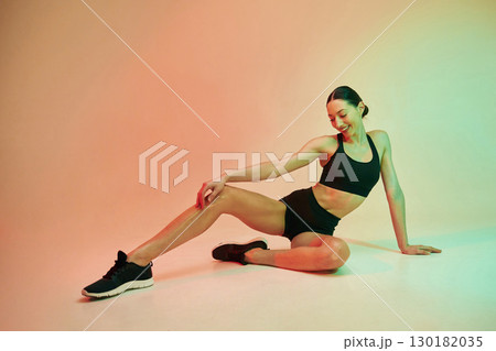 Skinny body shape. Young fitness woman in sportive clothes against background in studio Skinny body shape. Young fitness woman in sportive clothes against background in studio 130182035