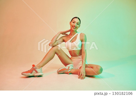 Looking forward. Young fitness woman in sportive clothes against background in studio 130182106