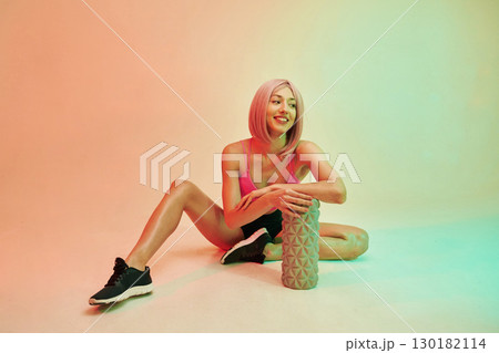 Smiling, positive facial expression. Sportive woman with pink wig is against background Smiling, positive facial expression. Sportive woman with pink wig is against background 130182114