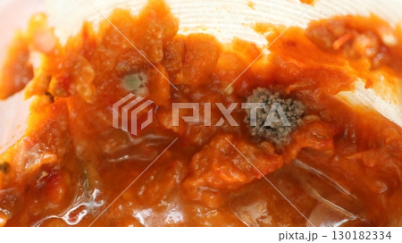 close up of moldy vegetable dish with grey mold growths, spoiled food from orange mush with mold fungi 130182334