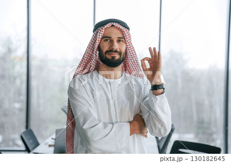 In traditional outfit. Successful Muslim businessman is in his office 130182645