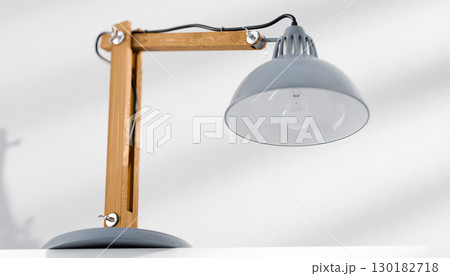 Retro or vintage style desk lamp, classic wooden arm with metal base and grey colored canopy, against white background, isolated. 130182718
