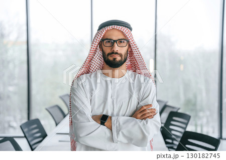 Young investor is standing. Successful Muslim businessman in traditional outfit in his office 130182745