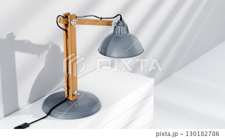 Retro or vintage style desk lamp, classic wooden arm with metal base and grey colored canopy, against white background, isolated. Retro or vintage style desk lamp, classic wooden arm with metal base and grey colored canopy, against white background, isolated. 130182786