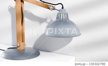 Retro or vintage style desk lamp, classic wooden arm with metal base and grey colored canopy, against white background, isolated. 130182790