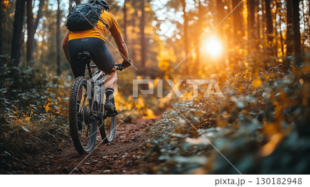 Cyclist Riding Through a Forest Trail at Golden Hour in Autumn Cyclist Riding Through a Forest Trail at Golden Hour in Autumn 130182948