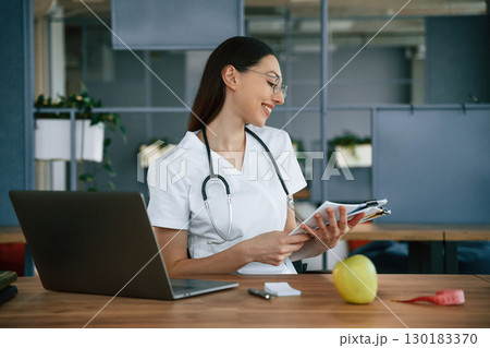 Vitamins, nutritionist, healthy eating concept. Female doctor in white coat is indoors Vitamins, nutritionist, healthy eating concept. Female doctor in white coat is indoors 130183370