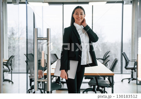 In black formal clothes. Businesswoman is indoors in the office 130183512