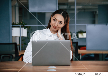 Working by using laptop. Businesswoman is indoors in the office 130183530