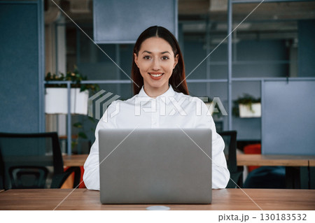 Working by using laptop. Businesswoman is indoors in the office Working by using laptop. Businesswoman is indoors in the office 130183532