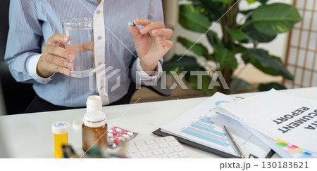 Office Syndrome Woman Preparing to Take Medication at Work Office Syndrome Woman Preparing to Take Medication at Work 130183621