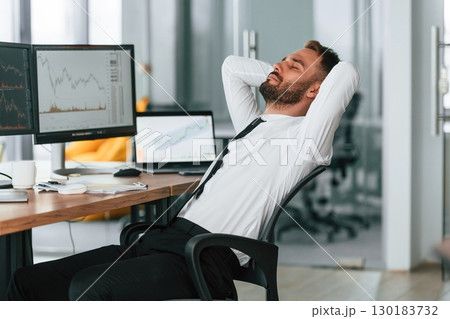 Taking a break, resting. Businessman is sitting by computer and working in the office 130183732