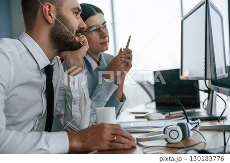 Analyzing information. Two employees are working in the office together 130183776