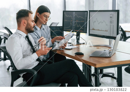 Focused on a project. Two employees are working in the office together 130183822