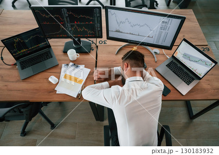 Tired, sleeping on the table. Businessman is sitting by computer and working in the office Tired, sleeping on the table. Businessman is sitting by computer and working in the office 130183932