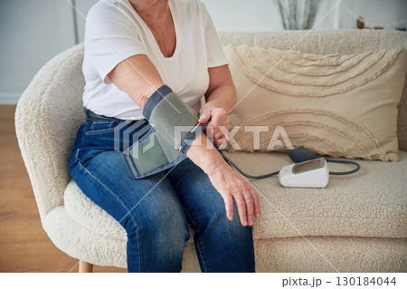 Pressure measurement. Senior elderly woman is at home in the living room 130184044