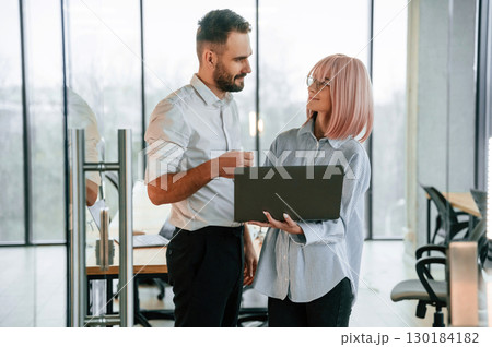Using laptop. Man and woman are working in the office together 130184182
