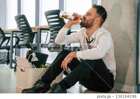 Drinking alcohol. Unemployed man is with personal belongings after being fired 130184298