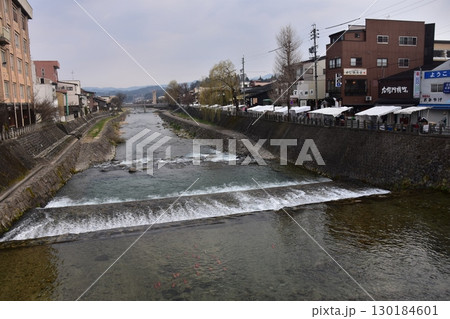 日本の岐阜県の高山市　中心部を流れる宮川と観光名所の宮川朝市　特産品を販売する露店や商店街 130184601