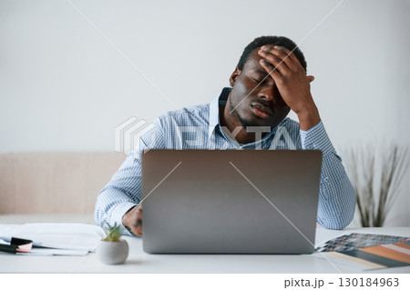 Feeling bad, stressful. Businessman is working in the office by laptop Feeling bad, stressful. Businessman is working in the office by laptop 130184963