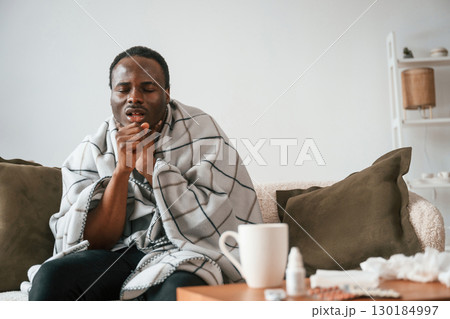 Pain in the throat. Sick black man is at home 130184997