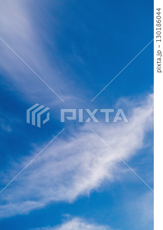 Landscape. A background of blue sky with blurred particles of clouds or other components in the upper atmosphere flowing in the wind. Displacement, the passage of time, abstract manifestations 130186044