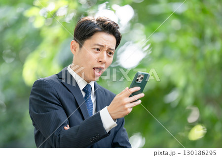 ビジネス 男性 新緑 スマホ 驚く ビジネス 男性 新緑 スマホ 驚く 130186295
