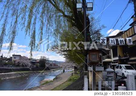 日本の岐阜県の高山市　中心部を流れる宮川と観光名所の宮川朝市　満開の桜と美しい青空　お昼過ぎの様子 130186523