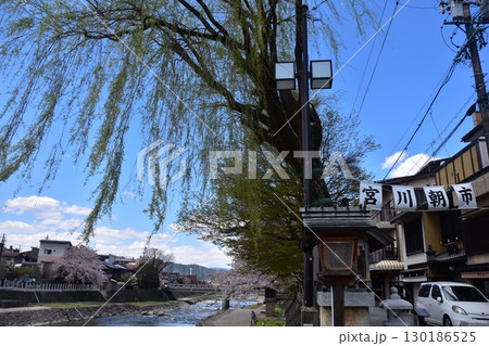 日本の岐阜県の高山市 中心部を流れる宮川と観光名所の宮川朝市 満開の桜と美しい青空 お昼過ぎの様子 日本の岐阜県の高山市 中心部を流れる宮川と観光名所の宮川朝市 満開の桜と美しい青空 お昼過ぎの様子 130186525