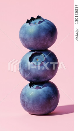 A stack of blueberry fruit balancing on top with pink solid background 130186857