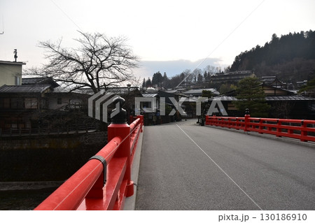 日本の岐阜県　春の高山祭期間中　観光名所の中橋と周辺の街並み　市内を流れる宮川とつぼみ状態の桜 130186910