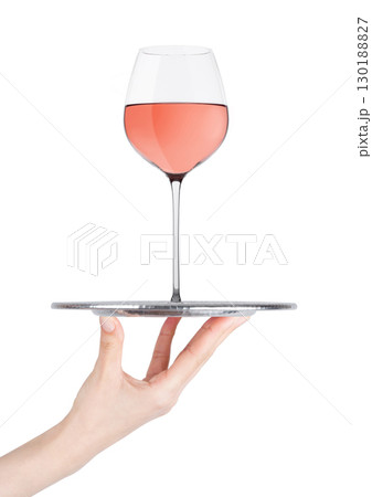 Hand holds tray with pink rose wine glass on white Hand holds tray with pink rose wine glass on white 130188827