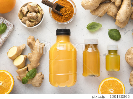 Ginger and orange energy shot immune drink with ginger root and turmeric powder.Top view. Ginger and orange energy shot immune drink with ginger root and turmeric powder.Top view. 130188866