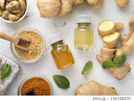 Bottles of immune turmeric ginger energy shot drink with fresh raw ginger roots and oranges fruits. 130188870