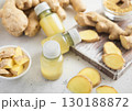 Immune ginger energy shot drink bottles with fresh raw ginger root on light background.Macro. 130188872