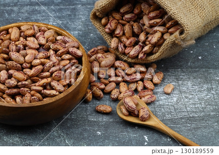 red kidney beans in wooden bowl isolated on dark background. red kidney beans in wooden bowl isolated on dark background. 130189559
