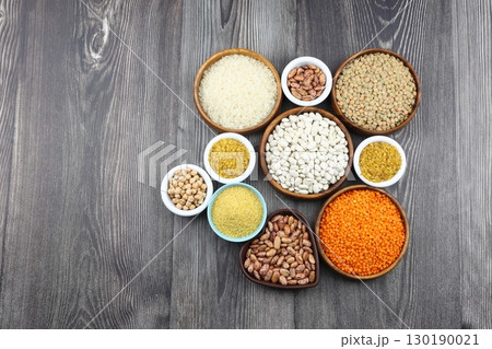 Different type of raw dry legumes composition. White Rice, lentils, red lentils, chickpeas and kidney beans. Mix organic legume concept. Different type of raw dry legumes composition. White Rice, lentils, red lentils, chickpeas and kidney beans. Mix organic legume concept. 130190021