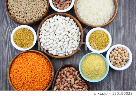 Different type of raw dry legumes composition. White Rice, lentils, red lentils, chickpeas and kidney beans. Mix organic legume concept. Different type of raw dry legumes composition. White Rice, lentils, red lentils, chickpeas and kidney beans. Mix organic legume concept. 130190022
