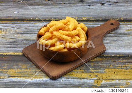 Puffed corn peanuts snacks isolated on wooden background. 130190242