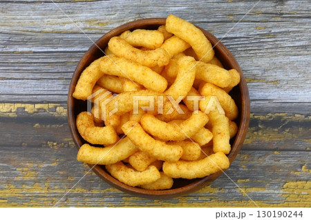 Puffed corn peanuts snacks isolated on wooden background. Puffed corn peanuts snacks isolated on wooden background. 130190244