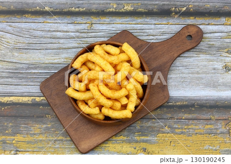 Puffed corn peanuts snacks isolated on wooden background. 130190245