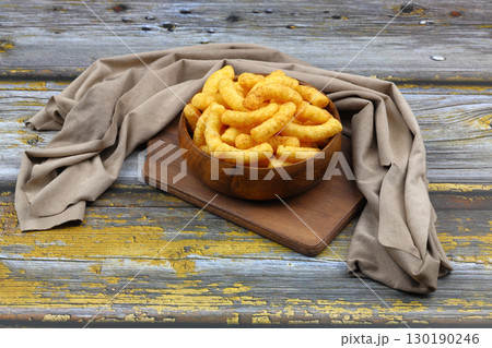 Puffed corn peanuts snacks isolated on wooden background. 130190246