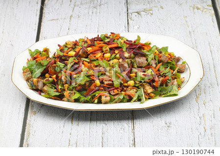 Mixed fresh Turkish salad. Carrots, arugula, cucumber, basil, pepper, black cumin, pepper, corn and plenty of olive oil in a serving plate. Healthy summer food. 130190744